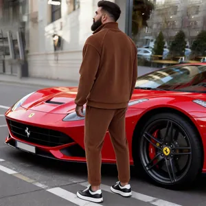 Rear view of man wearing brown corduroy half-zip tracksuit next to red luxury car