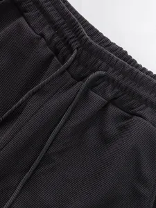 Macro detail of the black waffle texture drawstring waistband on these casual straight-leg pants