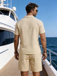 Rear view of a men's beige linen shirt and shorts set on a luxury yacht deck setting.