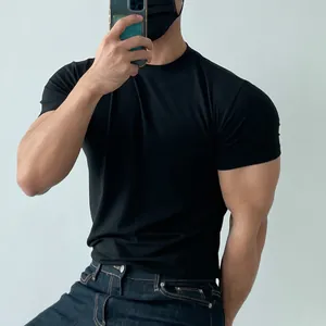 Close-up of a black crew neck fitness t-shirt showing a snug fit on a muscular build.