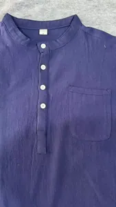 Dettaglio di una camicia blu in cotone e lino con colletto alla coreana e tasca frontale.