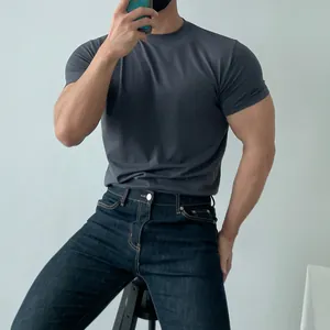Detailed view of dark gray athletic training T-shirt showing tight fit and muscle definition.