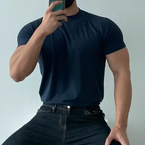 Detail view of a muscular man wearing a navy blue slim-fit athletic training T-shirt