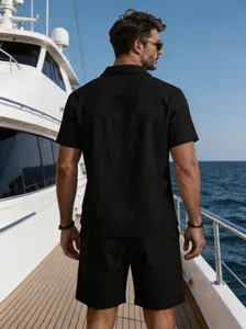 Rear view of model in black linen short sleeve shirt set on a luxury yacht deck