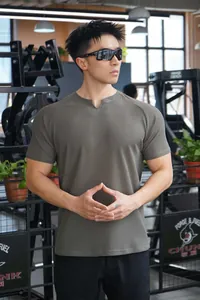 Gros plan d'un t-shirt de sport en maille moulant pour homme porté par un modèle en salle.