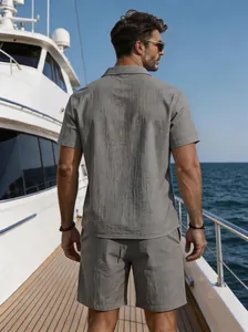 Back view of a man wearing a grey linen short-sleeve shirt and matching shorts on a yacht