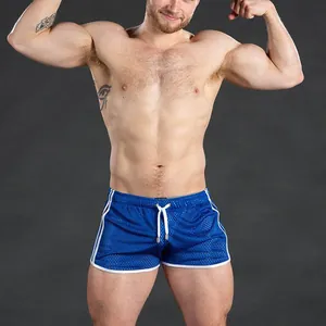 Close-up detail of blue mesh quick-dry fitness shorts worn by a muscular athlete.