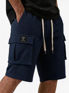 Detailansicht der dunkelblauen Waffelstrick-Cargo-Shorts für Herren mit Kordelzug