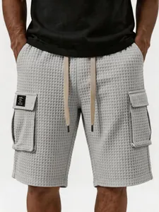 Detailaufnahme von grauen Cargo-Shorts aus Waffelstrick für Herren mit Tunnelzug