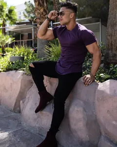 Muscular man wearing a purple slim fit cotton T-shirt in an outdoor casual setting.