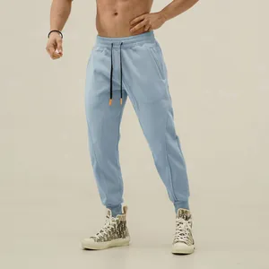 Detailed view showing the fit of men's light blue joggers with drawstring and ribbed cuffs