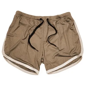 Detailweergave van bruine ademende mesh sportshorts met witte bies en zwart trekkoord