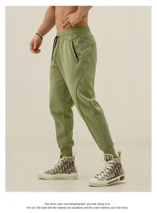 Detailed side view of olive green men's tapered joggers featuring zipper pocket details