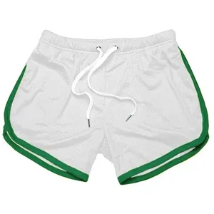Gedetailleerde weergave van witte mesh sportshorts met groene bies en een wit trekkoord.