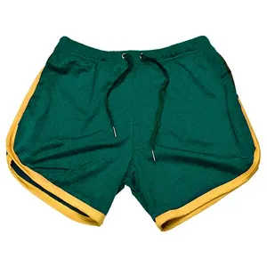Detail van groene mesh sportshort met gele contrasterende bies en trekkoord.