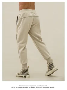 Detailed back view of men's beige slim-fit athletic joggers with elastic ribbed ankle cuffs
