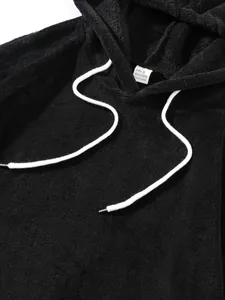 Détail en gros plan d'un sweat à capuche en polaire noire montrant la texture douce