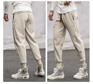 Close-up detail of cream men's sports joggers featuring cuffed ankles and secure zipper pockets