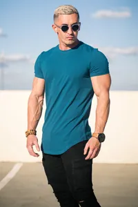 Outdoor detailed view of teal cotton short-sleeved T-shirt on a muscular male model.