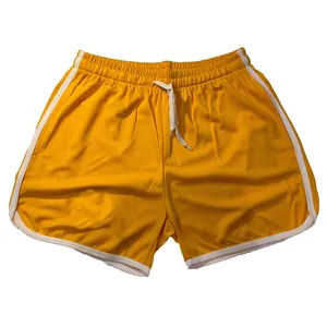 Close-up van gele sneldrogende mesh sportshorts met witte bies en elastische taille