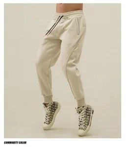 Detailed close-up of beige men's athletic joggers featuring a flexible drawstring waist