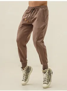 Detail view of men's brown tapered sports joggers with elastic drawstring waist