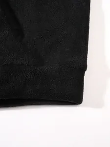 Vue macro du tissu en polaire corail noir montrant la texture douce et le poignet