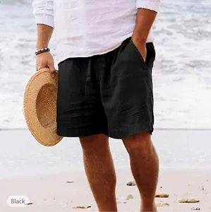 Pantaloncini mare neri in lino da uomo con coulisse, sulla spiaggia con cappello.