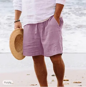 Dettaglio dei pantaloncini da spiaggia in cotone e lino viola da uomo su una spiaggia soleggiata.