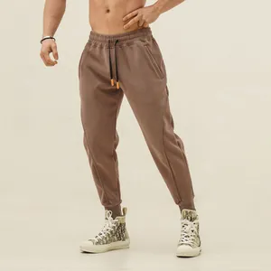 Detail of men's taupe sports joggers showing cuffed hem and comfortable athletic fit