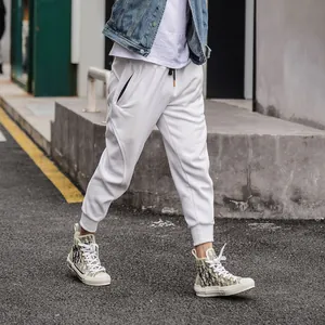Detail of men's white American-style slim-fit joggers with zipper pockets
