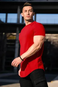 Detailed side view of red muscle fit T-shirt featuring a stylish curved hem.