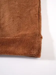 Makroansicht von weichem braunem Korallenvlies-Stoff für Herren-Hoodie- und Shorts-Set.