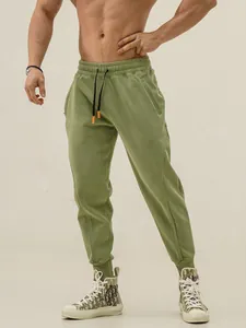 Men's olive green American style sports joggers with zipper pockets and drawstring