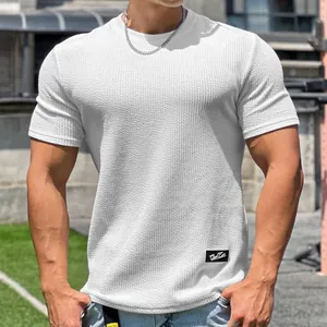 Primo piano di t-shirt fitness bianca in maglia waffle con dettaglio del tessuto.