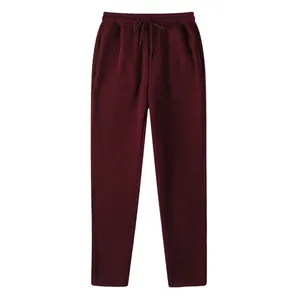 Detail view of burgundy fleece-lined men's slim fit sports joggers with adjustable drawstring