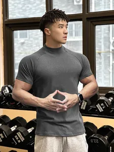 Charcoal grey mock neck compression t-shirt worn by a fit model in a gym setting