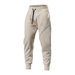 Detailed view of beige men's fleece-lined sports joggers with tapered cuffs and drawstring