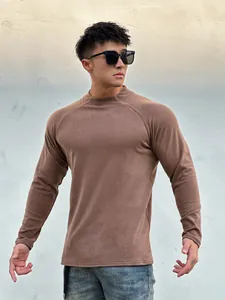 Detail view of a men's slim-fit muscle-enhancing long-sleeved brown T-shirt on a model.