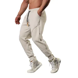 Side view of men's beige jogger sweatpants with diagonal seam detail shown on model