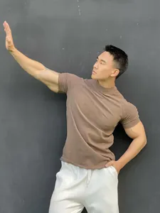 Close-up of men's brown high-neck athletic t-shirt showing fabric texture and fit