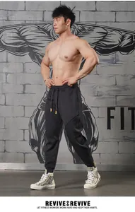 Full body detail of men's black athletic joggers featuring structural paneling and cuffed ankles.