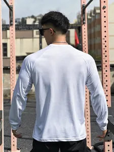 Back view of a man wearing a white mesh long sleeve athletic T-shirt in an outdoor gym