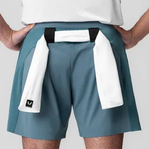 Detail van blauwe hardloopshort voor heren met handdoeklussen en witte handdoek.