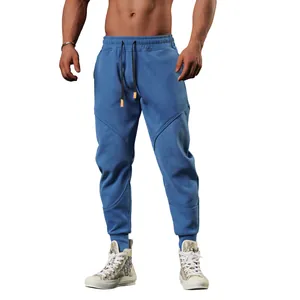 Detail of men's blue athletic joggers featuring unique seam design and cuffed ankles.