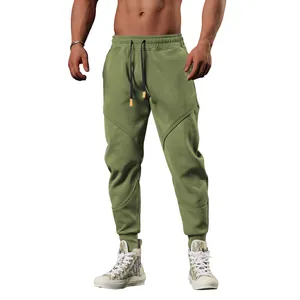 Close-up of olive green men's joggers with unique paneled stitching and drawstring waist
