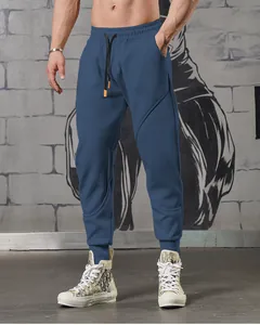 Detail view of men's blue paneled sports joggers featuring elastic waist and drawstrings.