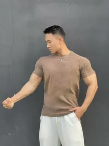 Detail shot of a muscle fit men's gym t-shirt in brown velvet cotton on an athletic model