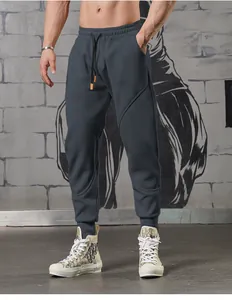 Detailed view of men's charcoal grey athletic joggers with cuffed ankles on model.