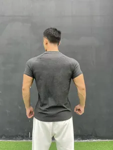 Back view of a slim fit charcoal gray athletic t-shirt on a male model outdoors